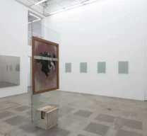 Sala principal de galeria de arte com pé-direito alto, cavalete de vidro e concreto da Lina Bo Bardi com obra de arte exposta de Dora Longo Bahia e paredes brancas com diferentes instalações.